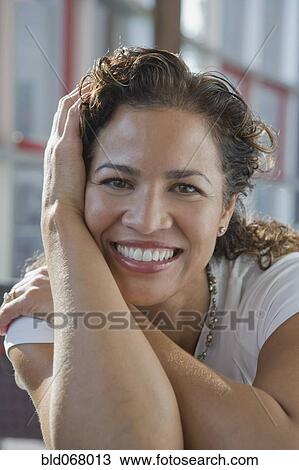 Stock Image - Hispanic businesswoman with head in hands. Fotosearch
