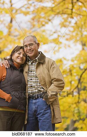 Stock Photo - Hispanic couple hugging outdoors in autumn. Fotosearch
