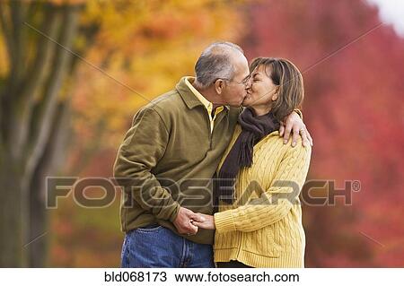 Stock Image - Hispanic couple kissing outdoors in autumn. Fotosearch