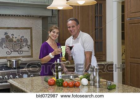 Hispanic couple posing with wine in kitchen View Large Photo Image Stock Photo - Hispanic couple posing with wine in kitchen. Fotosearch