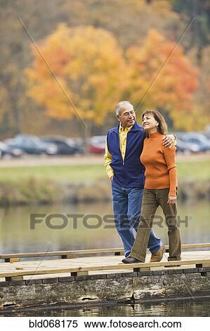 Stock Photography - Hispanic couple walking on pier. Fotosearch