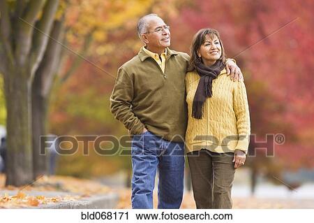 Hispanic couple walking outdoors in autumn View Large Photo Image Stock Image - Hispanic couple walking outdoors in autumn. Fotosearch