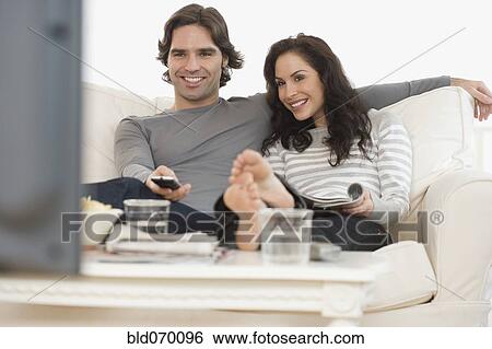 Hispanic couple watching television on sofa View Large Photo Image Stock Photograph - Hispanic couple watching television on sofa. Fotosearch