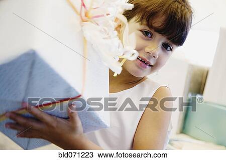 Hispanic girl holding gift View Large Photo Image Stock Image - Hispanic girl holding gift. Fotosearch