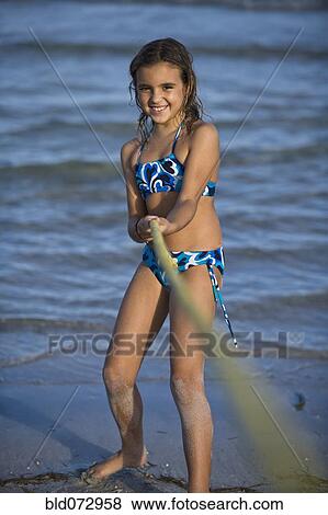 Hispanic girl playing tug-of-war on beach View Large Photo Image Stock Photo - Hispanic girl playing tug-of-war on beach. Fotosearch