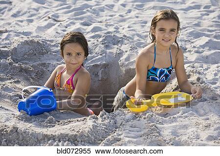 Hispanic girls digging in sand View Large Photo Image Stock Photography - Hispanic girls digging in sand. Fotosearch