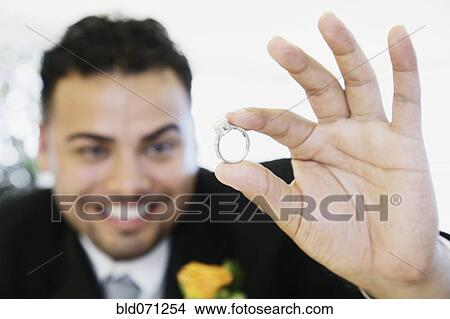 Picture - Hispanic groom showing ring. Fotosearch