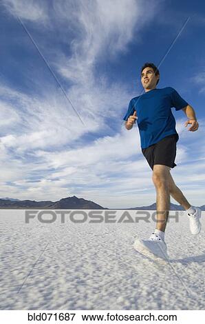 Hispanic man jogging on salt flats View Large Photo Image Stock Photo - Hispanic man jogging on salt flats. Fotosearch