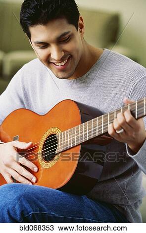 Stock Image - Hispanic man playing guitar. Fotosearch