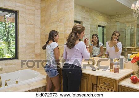 Hispanic mother and teenage daughter in front of bathroom mirror View Large Photo Image Stock Image - Hispanic mother and teenage daughter in front of bathroom mirror. Fotosearch