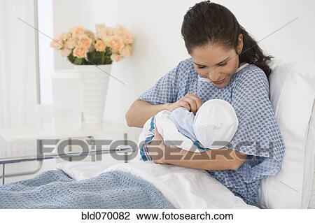 Hispanic mother holding newborn baby in hospital bed View Large Photo Image Stock Image - Hispanic mother holding newborn baby in hospital bed. Fotosearch