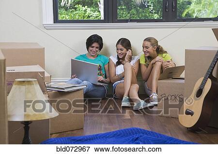 Stock Photo - Hispanic teenage girls and woman using laptop. Fotosearch