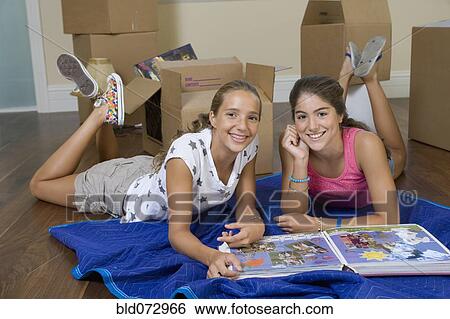 Stock Photograph - Hispanic teenage girls with photograph album. Fotosearch