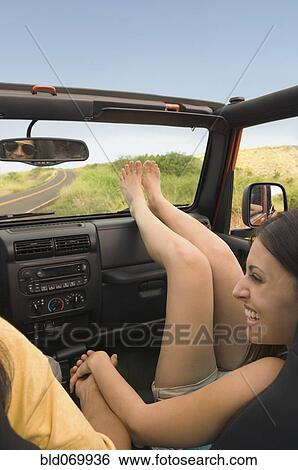 Stock Photograph - Hispanic woman holding boyfriend's hand in jeep. Fotosearch