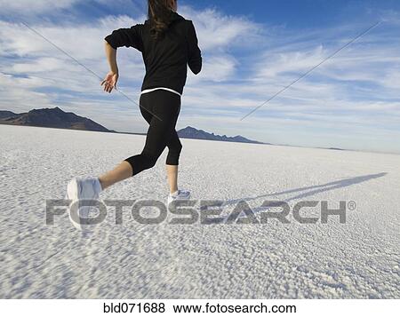 Hispanic woman jogging on salt flats View Large Photo Image Stock Photo - Hispanic woman jogging on salt flats. Fotosearch