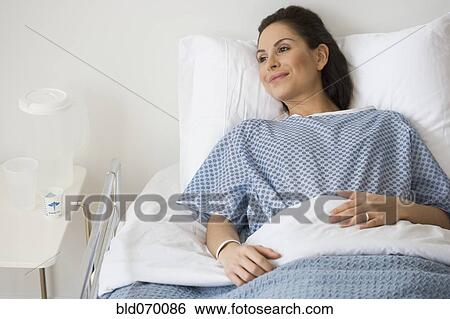 Stock Photograph - Hispanic woman laying in hospital bed. Fotosearch