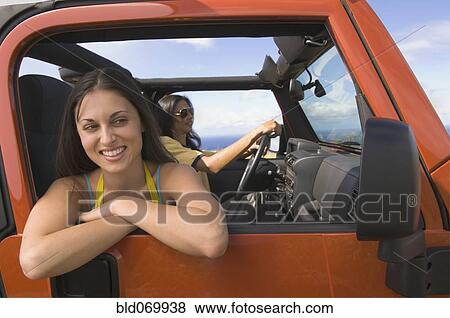 Stock Photo - Hispanic woman leaning out window of jeep. Fotosearch