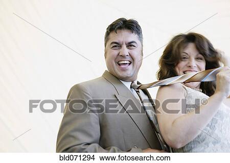 Hispanic woman pulling husband by tie View Large Photo Image Picture - Hispanic woman pulling husband by tie. Fotosearch
