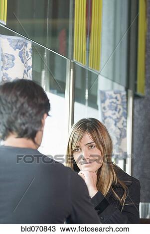Stock Image - Hispanic woman smiling at boyfriend. Fotosearch