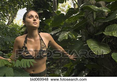 Stock Photo - Hispanic woman wearing camouflage bikini in jungle. Fotosearch