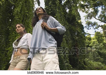 Stock Photograph - Low angle view of couple in forest. Fotosearch