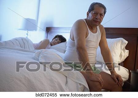 Stock Photography - Man in bedroom waking up in the morning. Fotosearch