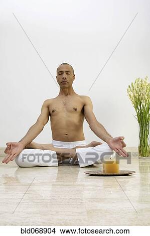 Man meditating with candle View Large Photo Image Picture - Man meditating with candle. Fotosearch