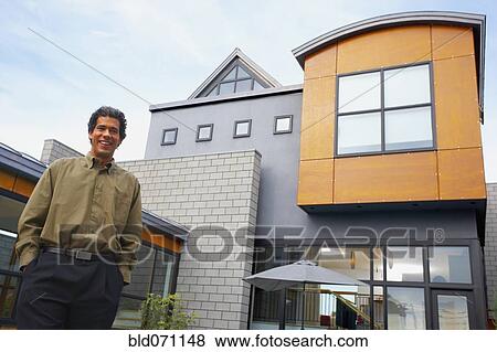 Stock Photo - Man standing in front of house. Fotosearch
