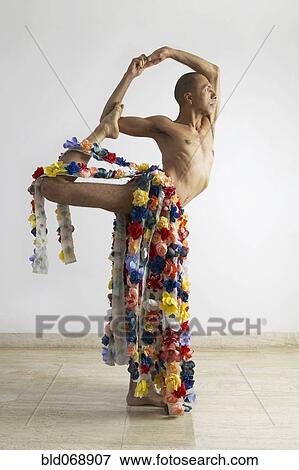 Stock Photo - Man stretching and wearing skirt of flowers. Fotosearch