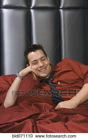 Man wearing shirt and tie on bed View Large Photo Image Stock Image - Man wearing shirt and tie on bed. Fotosearch