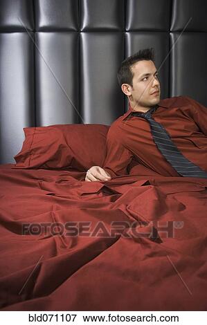 Man wearing shirt and tie on bed View Large Photo Image Stock Photo - Man wearing shirt and tie on bed. Fotosearch