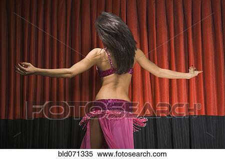 Stock Photography - Middle Eastern woman belly dancing on stage. Fotosearch
