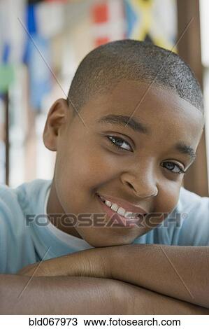 Stock Image - Mixed race boy with arms crossed. Fotosearch