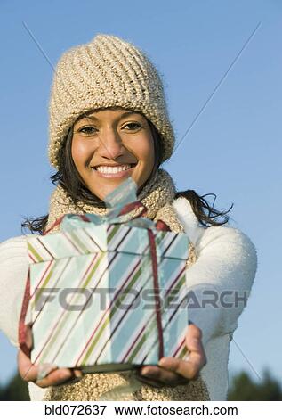 Mixed race businesswoman holding gift View Large Photo Image Stock Photo - Mixed race businesswoman holding gift. Fotosearch