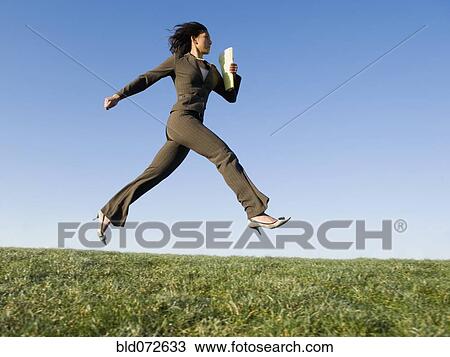 Mixed race businesswoman leaping in field View Large Photo Image Stock Image - Mixed race businesswoman leaping in field. Fotosearch