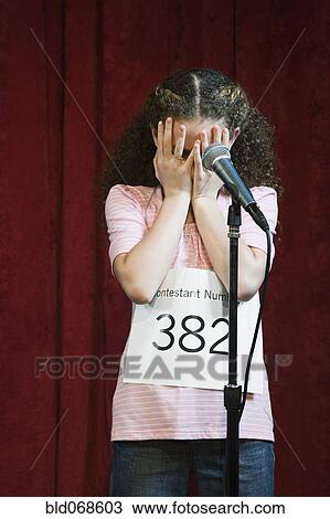 Stock Image - Mixed race girl competing in spelling bee. Fotosearch