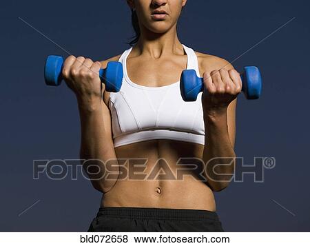 Mixed race woman doing biceps curls with dumbbells View Large Photo Image Stock Photo - Mixed race woman doing biceps curls with dumbbells. Fotosearch