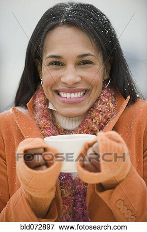 Mixed race woman drinking coffee in snow View Large Photo Image Stock Photo - Mixed race woman drinking coffee in snow. Fotosearch
