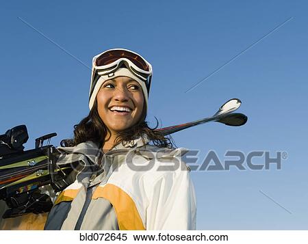 Mixed race woman holding skis View Large Photo Image Stock Photography - Mixed race woman holding skis. Fotosearch