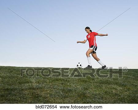 Mixed race woman kicking soccer ball View Large Photo Image Picture - Mixed race woman kicking soccer ball. Fotosearch