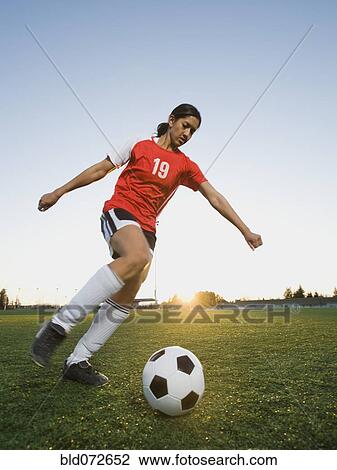 Mixed race woman kicking soccer ball View Large Photo Image Stock Image - Mixed race woman kicking soccer ball. Fotosearch