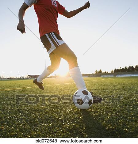 Mixed race woman kicking soccer ball View Large Photo Image Stock Photo - Mixed race woman kicking soccer ball. Fotosearch