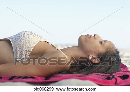 Mixed race woman laying on back at beach View Large Photo Image Stock Photo - Mixed race woman laying on back at beach. Fotosearch