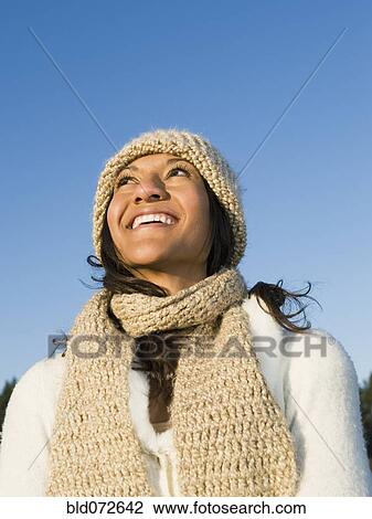 Stock Image - Mixed race woman looking up and smiling. Fotosearch