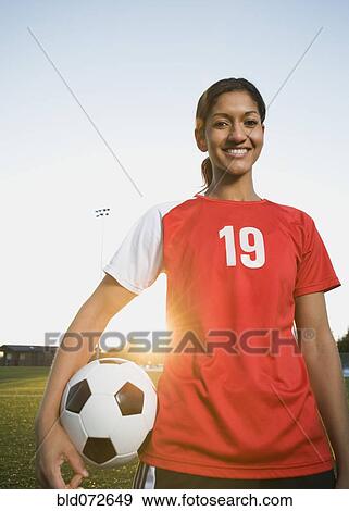 Stock Photo - Mixed race woman posing with soccer ball. Fotosearch
