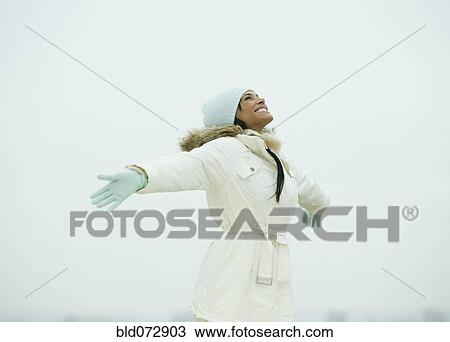 Mixed race woman standing in snow with arms outstretched View Large Photo Image Stock Image - Mixed race woman standing in snow with arms outstretched. Fotosearch