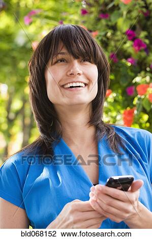 Mixed race woman text messaging on cell phone View Large Photo Image Stock Image - Mixed race woman text messaging on cell phone. Fotosearch