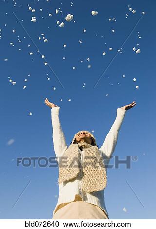 Mixed race woman throwing snow in air View Large Photo Image Stock Image - Mixed race woman throwing snow in air. Fotosearch