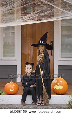 Stock Photo - Mixed race young girls in cat and witch costumes. Fotosearch