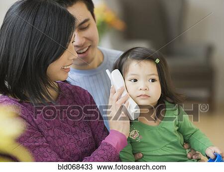 Mother and father holding telephone for daughter View Large Photo Image Stock Image - Mother and father holding telephone for daughter. Fotosearch